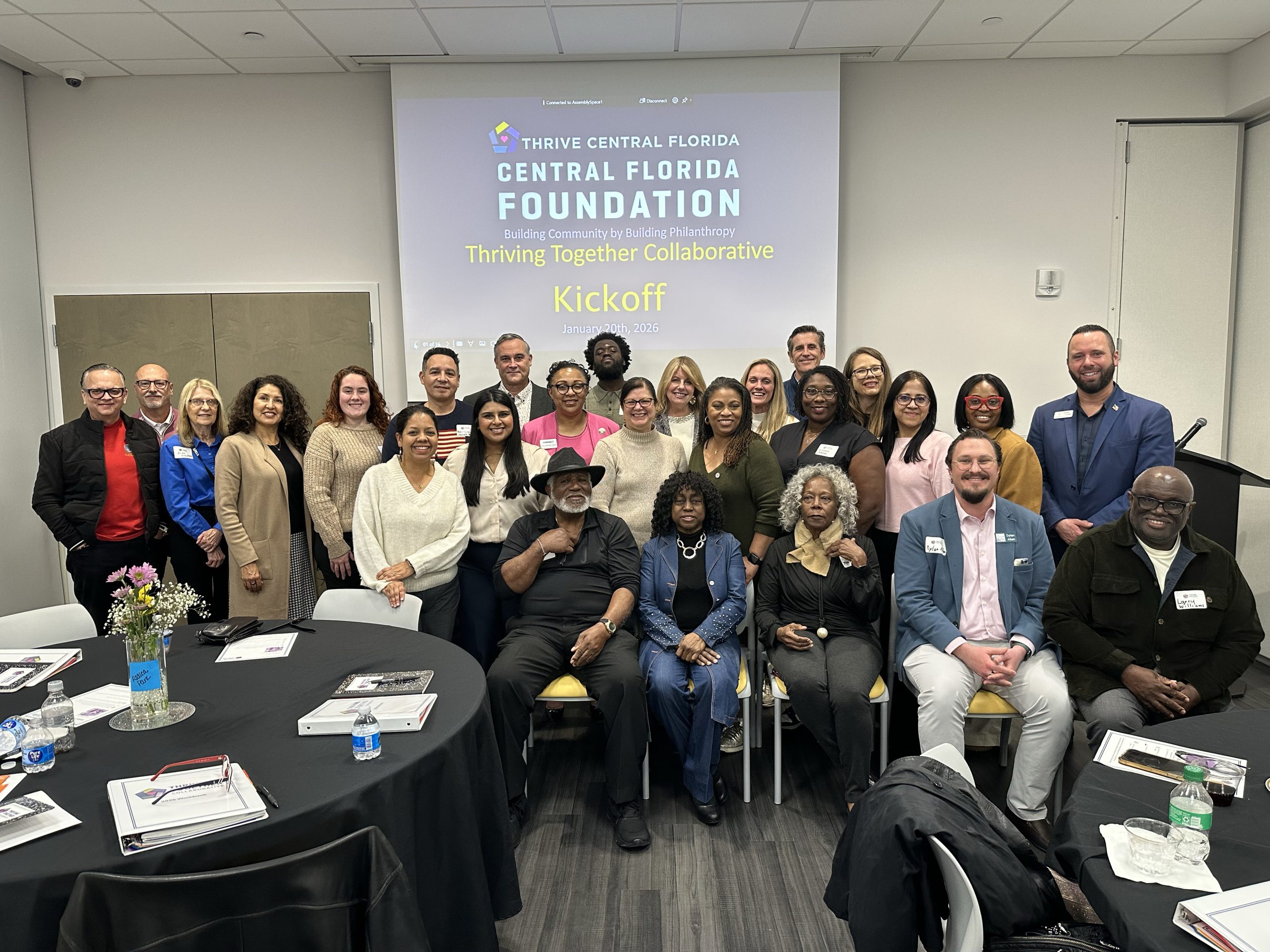 A group of people standing and sitting together for a photo. Thriving Together Collaborative
